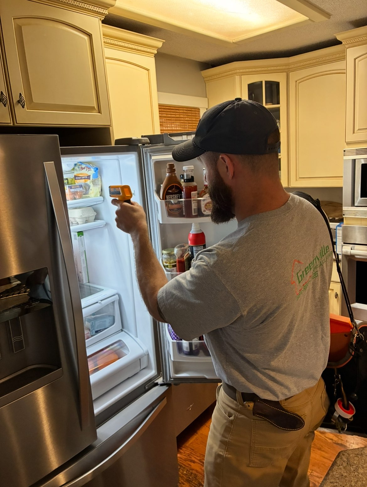 Blake Miller diagnosing a refrigerator in a customer's kitchen
